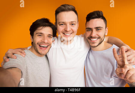Portrait of cheerful guys making selfie, having fun Stock Photo