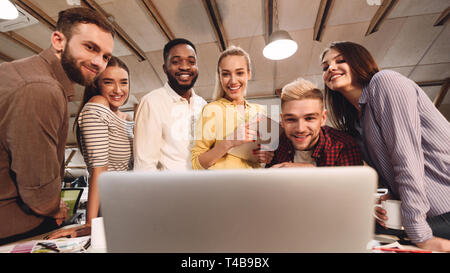 Software developers discussing new project, looking at laptop Stock Photo