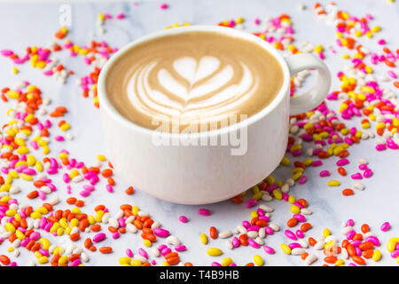 Cup of heart shape coffee with colorful sweet candies fresh and healthy tea Stock Photo