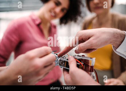 A midsection of scientist with robotic hand standing in office, working. Stock Photo