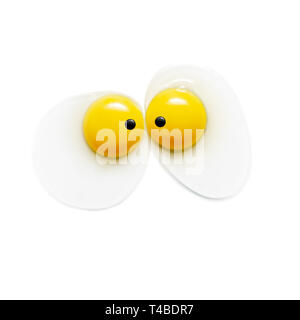 Two egg yolks with eyes on white background Stock Photo