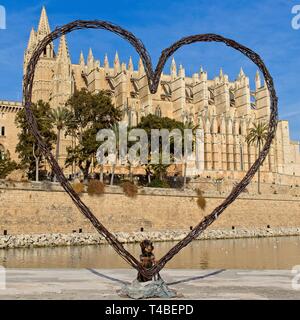 Palma cathedral with dachshund (teckel) dog posing for photograph inside large heart, palma, mallorca, spain. Stock Photo