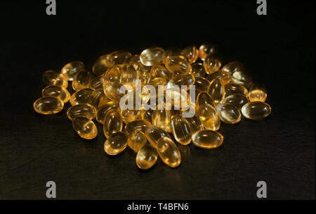 Evening primrose oil capsules on a black background Stock Photo