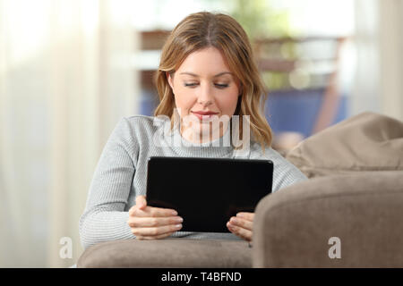 Front view portrait of a serious woman watching online tablet content at home Stock Photo
