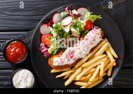 Lunch menu fried pollock with french fries and fresh salad close-up on a plate and sauces on the table. Horizontal top view from above Stock Photo