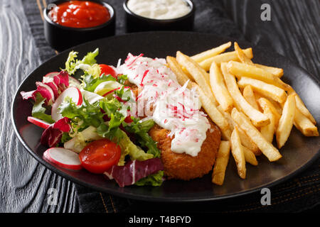 Served fried pollock in breading with french fries and fresh salad close-up on a plate and sauces on the table. horizontal Stock Photo