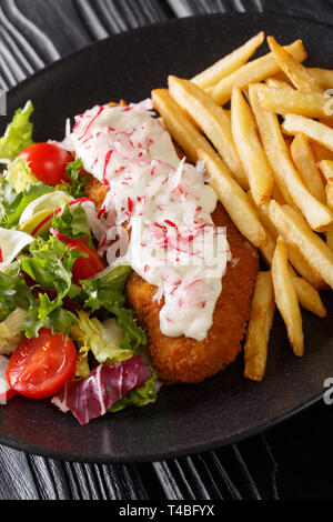 pollock in breadcrumbs garnished with French fries and fresh salad closeup on a plate. vertical Stock Photo