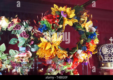 Wreath with sunflowers, poppies, daisies and cornflowers hanging on the stand Stock Photo