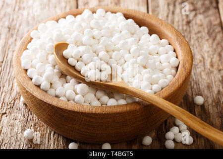 Heap of tapioca pearls close-up in a bowl on a wooden table. horizontal Stock Photo