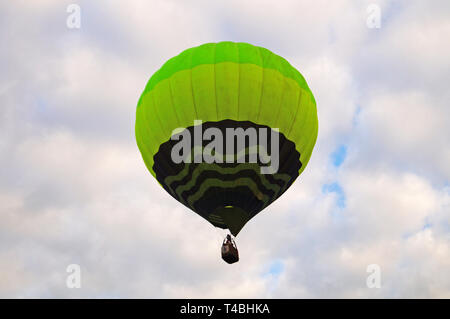Balloon blue and light green color rises into the sky with white clouds on a summer day Stock Photo