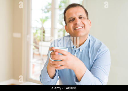 Middle age man enjoying and drinking a cup of coffee at home Stock Photo