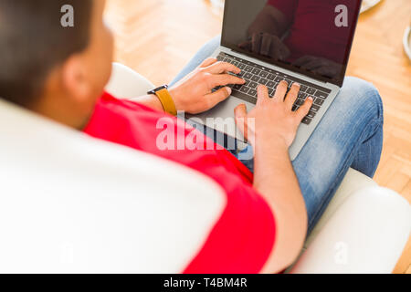 Middle age man using laptop sitting on the couch at home Stock Photo