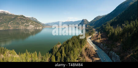 Aerial panoramic view of Sea to Sky Highway with Chief Mountain in the background during a sunny day. Taken near Squamish, North of Vancouver, British Stock Photo