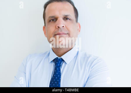 Middle age business man looking natural and relaxed with crossed arms over white wall background Stock Photo
