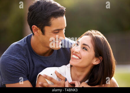 Young Hispanic couple looking at each other smiling, close up Stock Photo