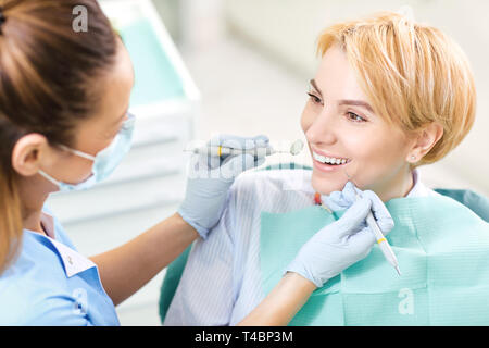 Dentist checks the teeth of a girl in the dental office Stock Photo