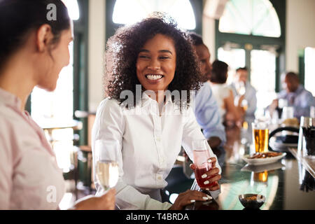 Two Businesswomen Meeting For After Works Drinks In Bar Stock Photo