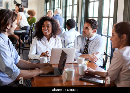 Business Team Having Informal Meeting Around Table In Coffee Shop Stock Photo