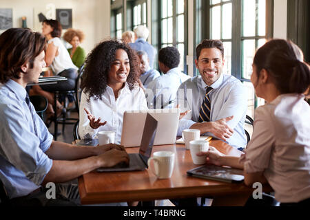 Business Team Having Informal Meeting Around Table In Coffee Shop Stock Photo