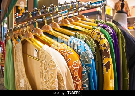 Choice of fashion clothes of different colors on  hangers Stock Photo