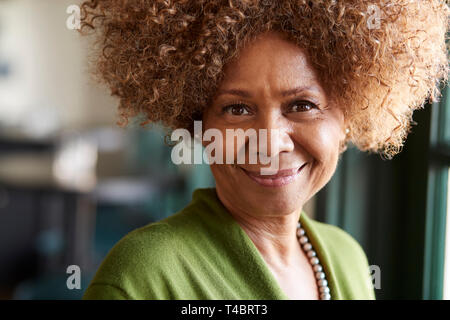 Portrait Of Smiling Senior Woman Sitting In Restaurant Stock Photo