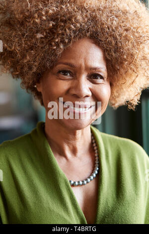 Portrait Of Smiling Senior Woman Sitting In Restaurant Stock Photo