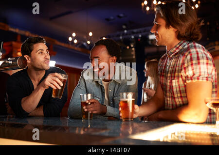 Group Of Male Friends Drinking Beer In Bar Together Stock Photo