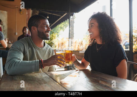 Young Couple Meeting In Sports Bar Enjoying Drink Before Game Stock Photo