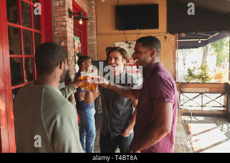 Group Of Male Friends Meeting In Sports Bar Making Toast Together Stock Photo