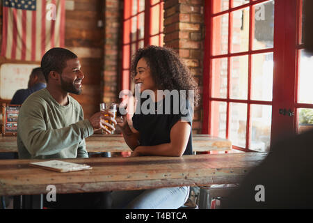 Young Couple Meeting In Sports Bar Making Toast Together Stock Photo
