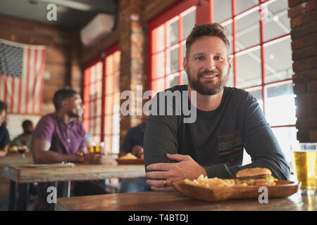 Portrait Of Man In Sports Bar Eating Burger And Fries Stock Photo