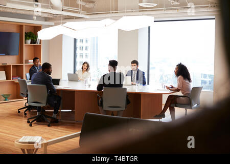 Group Of Business Professionals Meeting Around Table In Modern Office Stock Photo