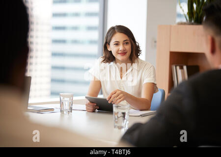 Businesswoman With Digital Tablet Sitting At Table Meeting With Colleagues In Modern Office Stock Photo