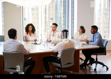 Group Of Business Professionals Meeting Around Table In Modern Office Stock Photo