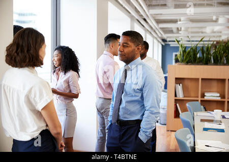 Group Of Business Colleagues Chatting In Office After Meeting Stock Photo