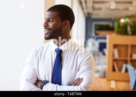 Businessman Wearing Smart Watch In Modern Office Standing By Window Stock Photo