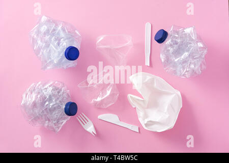 Disposable waste plastics on pink background. Top view. Stock Photo