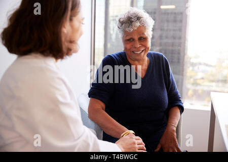 Female Doctor In Office Reassuring Senior Woman Patient And Holding Her Hands Stock Photo