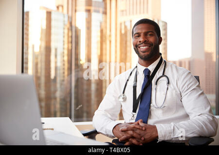 Portrait Of Smiling Male Doctor With Stethoscope In Hospital Office Stock Photo