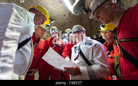 Gorleben, Germany. 15th Apr, 2019. Jochen Flasbarth (l), State Secretary in the Federal Ministry for the Environment, Nature Conservation and Nuclear Safety, is explained a map by Frank-Holger Koch (3rd from right), plant manager of Gorleben colliery. After decades of dispute over a repository for highly radioactive nuclear waste in Gorleben, the exploration area of the mine has been almost completely dismantled. During a symbolic final inspection of the salt dome it was now shown what the so-called open-keeping operation looks like. Credit: Philipp Schulze/dpa/Alamy Live News Stock Photo