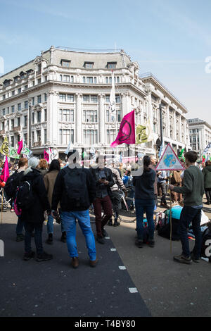 London, UK. 15th Apr, 2019. Climate change protesters In Oxford Circus and Regent street as Environmental protesters paralyse London's roads by creating human barricades at five landmarks. Extinction Rebellion organisers claim 30,000 eco-protesters are expected to block major routes today. They also pulled a boat up Regent Street to highlight the threat of Global Warming, but on a darker side they smashed windows at Shells headquarters. Credit: Keith Larby/Alamy Live News Stock Photo