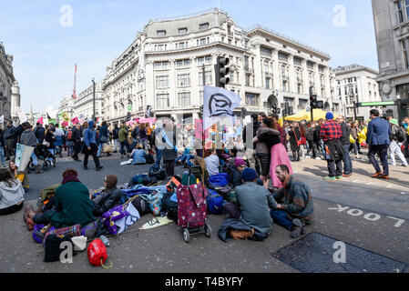 London, UK.  15 April 2019. People occupy Oxford Circus during 'London: International Rebellion', a protest organised by Extinction Rebellion, demanding that governments take action against climate change.  Marble Arch, Oxford Circus, Piccadilly Circus, Waterloo Bridge and Parliament Square have been blocked by activists.  According to the organiser, similar protests are taking place in 80 other cities around the world.    Credit: Stephen Chung / Alamy Live News