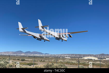 Mojave, California, USA. 13th Apr, 2019. The Stratolaunch aircraft takes first flight early Saturday at Mojave Air and Space Port in Mojave, CA. The aircraft is the largest aircraft ever made and with a wingspan of 385 ft. It has 6 747 engines and 3 sets of 747 landing gear on each fusilage. The aircraft was designed by legendary designer Burt Rutan and under contract for Paul Allen. The aircraft was designed for single purpose- to launch satellite bearing rockets from a high altitude. Shown here coming in for its first landing. Credit: Mark Greenberg/ZUMA Wire/Alamy Live News Stock Photo