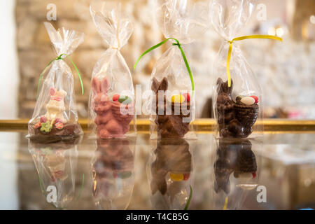 16 April 2019, Bavaria, Schweinfurt: Easter bunnies made of different types of chocolate, various colours and representations are standing on a table in the Chocolaterie Molina, a chocolate factory. Easter is also a festival for the confectionery industry. But chocolate manufacturers have to face up to the increased demands of consumers.  (for dpa: "Chocolate manufacturer between tradition and trends"). Photo: Daniel Karmann/dpa Stock Photo