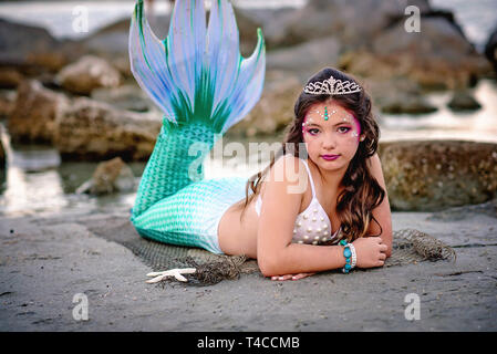 Tween mermaid on rocks Stock Photo