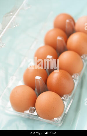 Ten brown chicken eggs in the transparent plastic package. Shallow depth of field Stock Photo