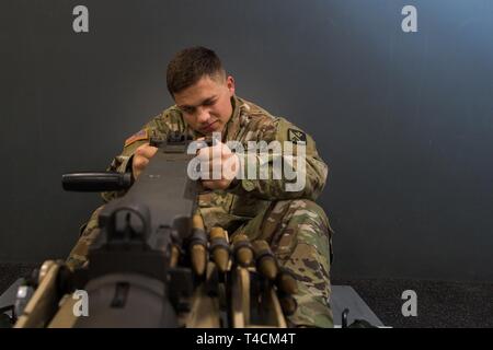U.S. Army Pvt. Andrew Carlisle, Foxtrot Company, 1st Battalion, 210th Aviation Regiment, 128th Avn. Brigade student, trains at the Engagement Skills Trainer at Joint Base Langley-Eustis, Virginia, March 20, 2019. The EST is designed to act like a real firearm and provide detailed feedback to the individual firing the weapon. Stock Photo