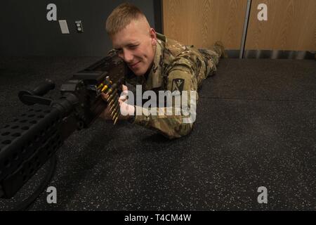 U.S. Army Pvt. Stefan Caswell, Foxtrot Company, 1st Battalion, 210th Aviation Regiment, 128th Avn. Brigade student, trains at the Engagement Skills Trainer at Joint Base Langley-Eustis, Virginia, March 20, 2019. While Soldiers primarily train with the M4, the EST has a list of weapons units can train with. Stock Photo