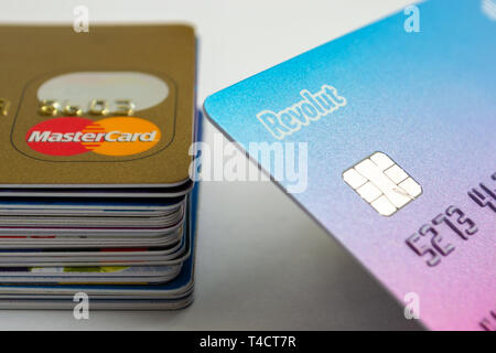 London, UK - March 14, 2019: Revolut chip card next to a stack of debit and credit cards with a Mastercard on top. Revolut Ltd is a UK financial techn Stock Photo