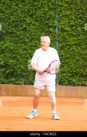 Old active man play tennis on summer Stock Photo